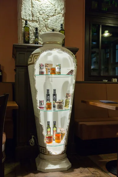 Vitrine in Amphorenform mit Spirituosen