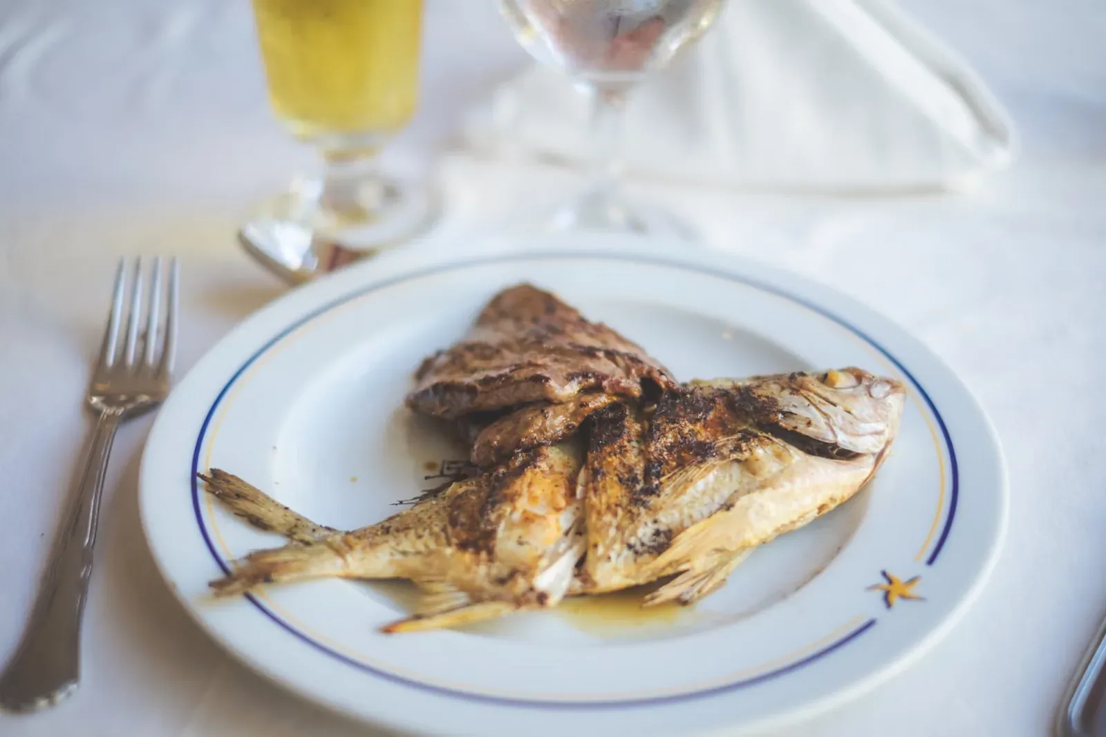 Ganzer gegrillter Fisch auf einem Teller, Stimmungsbild